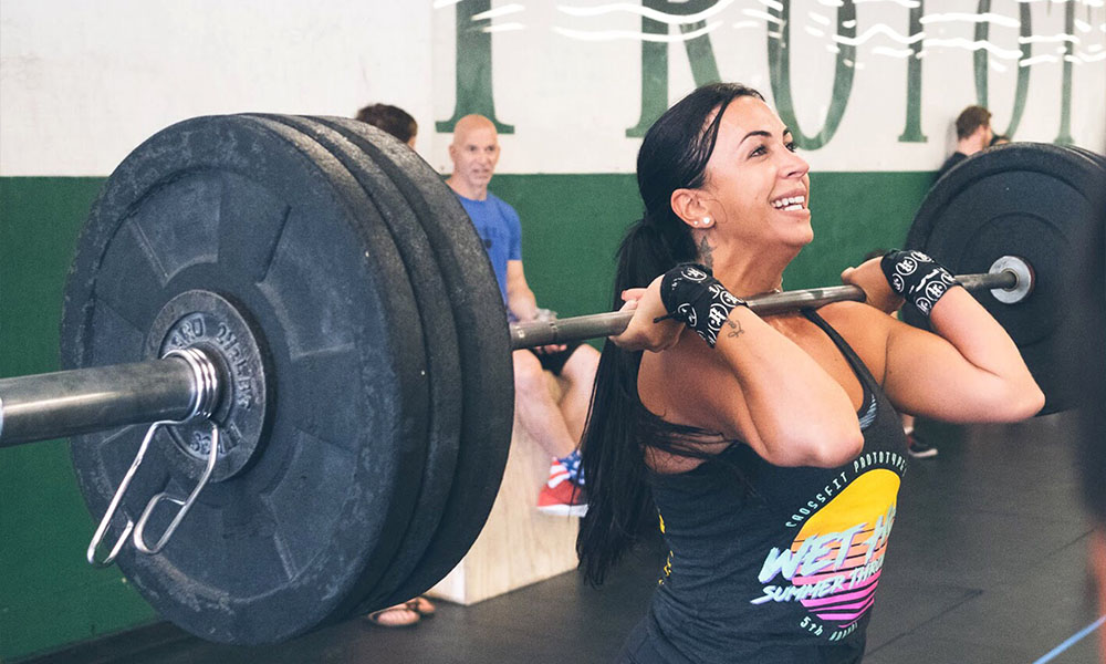Woman lifting barbell in group class